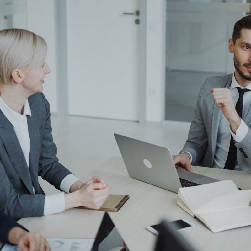 Four professionals in a business meeting around a table.